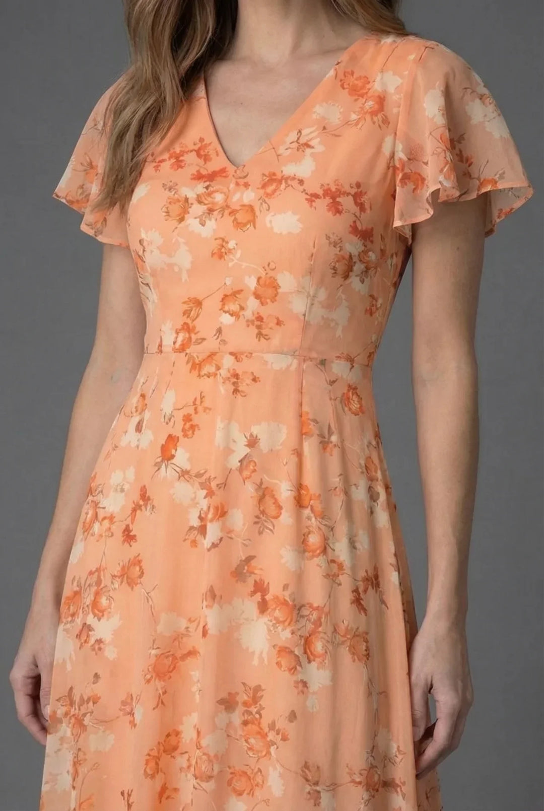 Flowy floral maxi dress for women, ideal for wedding guests or garden parties. Features V-neck and flutter sleeves.
