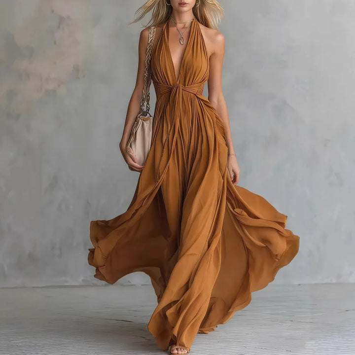 Formal women's evening gown: a stunning backless, flowy, pleated maxi dress with a chic halter neck.