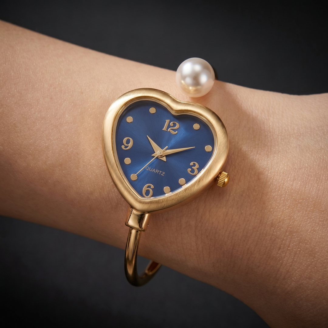Women's delicate gold quartz watch featuring a pearl and heart design. Stylish bracelet jewelry timepiece.