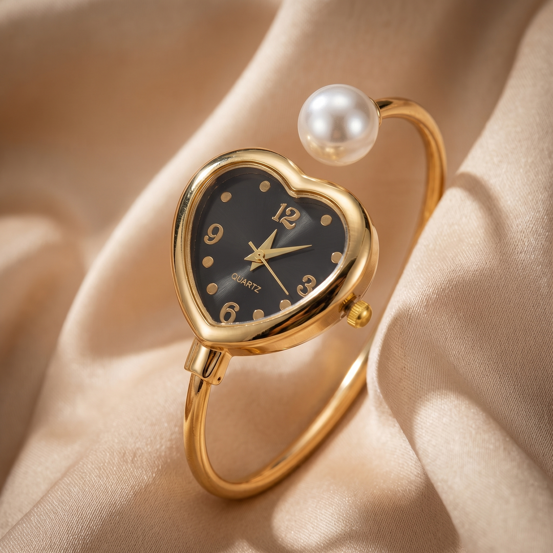 Fashionable women's pearl and heart accent quartz watch in elegant gold. A delicate jewelry bracelet timepiece.