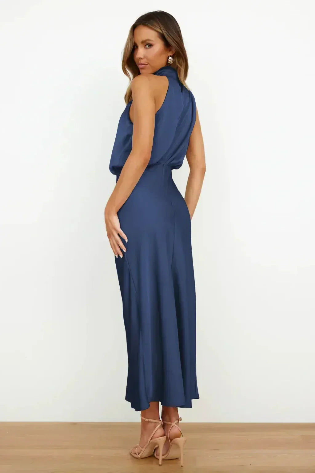 Women's halter evening gown with open back and flowing floor-length skirt, perfect for formal events.