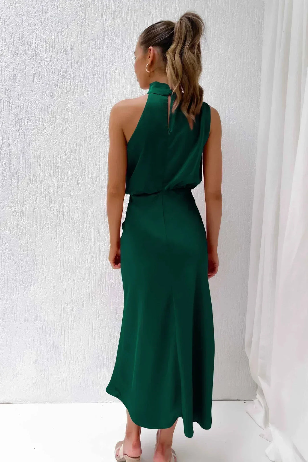 Elegant women's halter evening gown, open back, flowing skirt, ideal long formal dress for wedding guests.