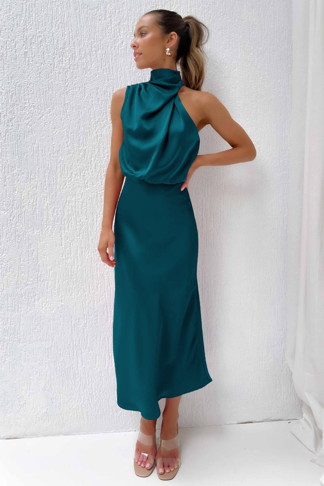 Modern women's halter formal dress, open back, flowing silhouette, long for elegant evening events.