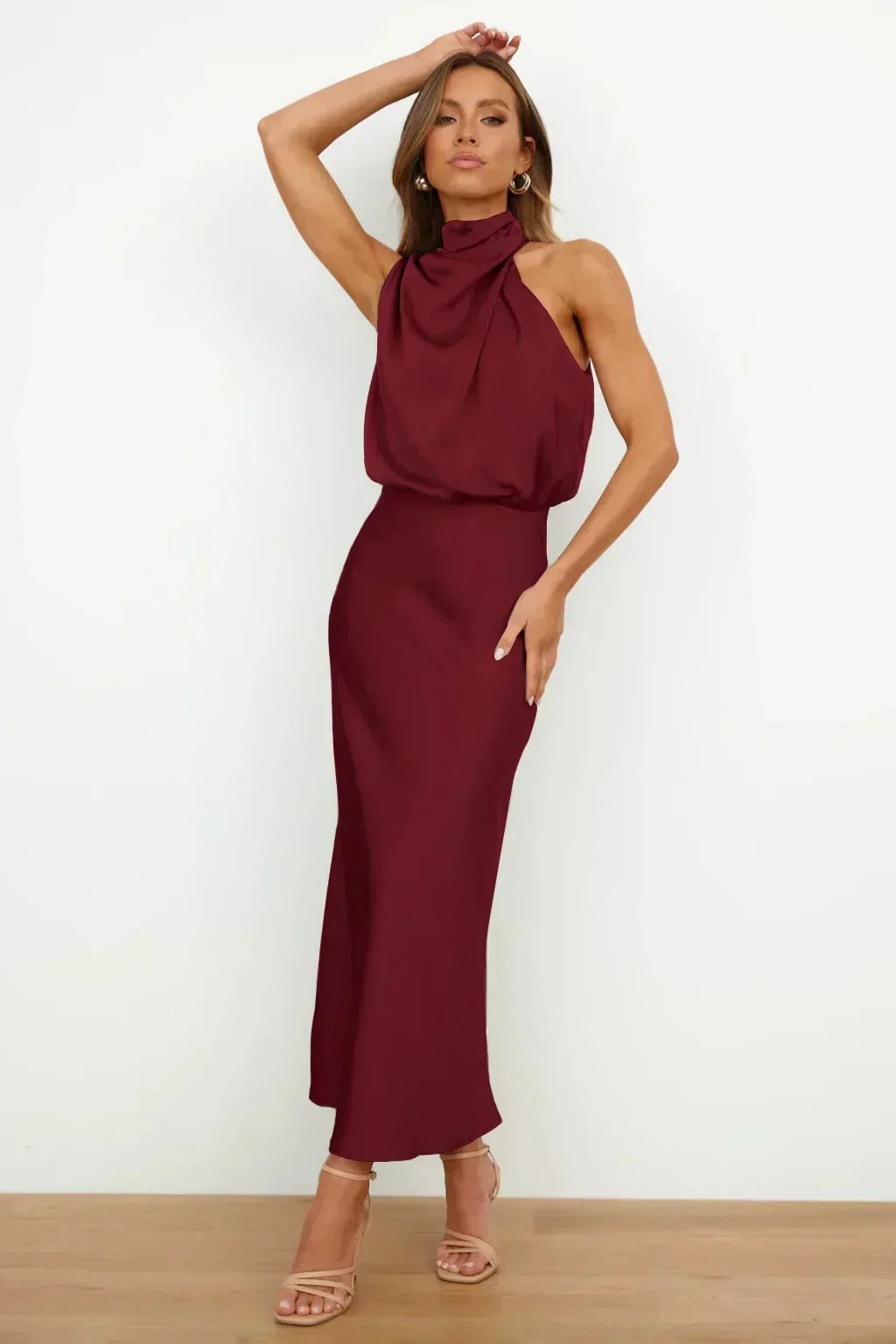 Flowing women's halter evening gown, open back, floor-length, elegant silhouette for special occasions.