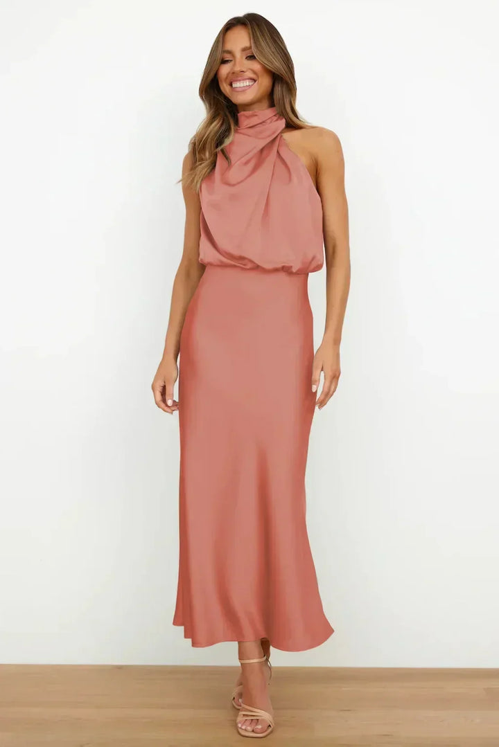 Rich sapphire blue women's halter evening gown, flowing skirt, open back, perfect for formal parties.