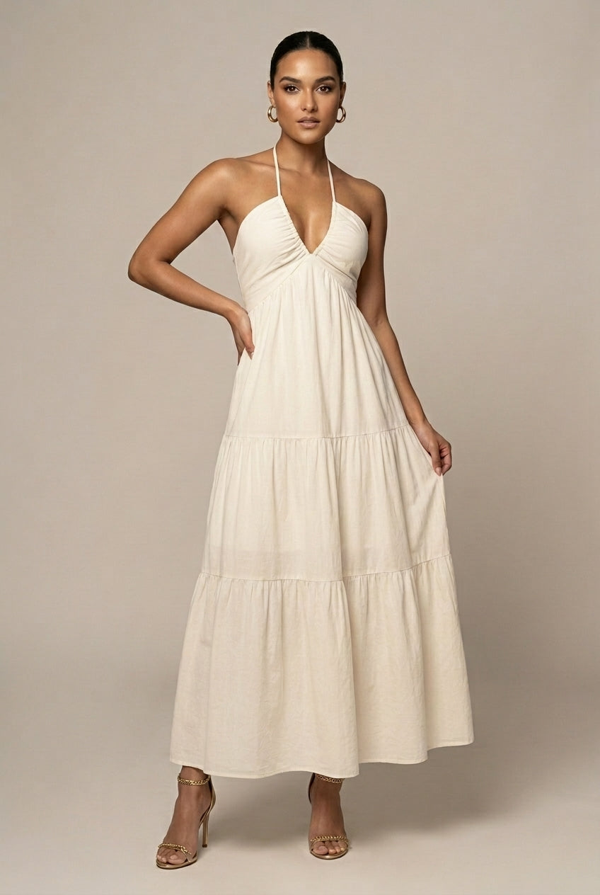 Elegant women's halter neck maxi dress with tiered ruffle skirt, open back, and tie waist detail.