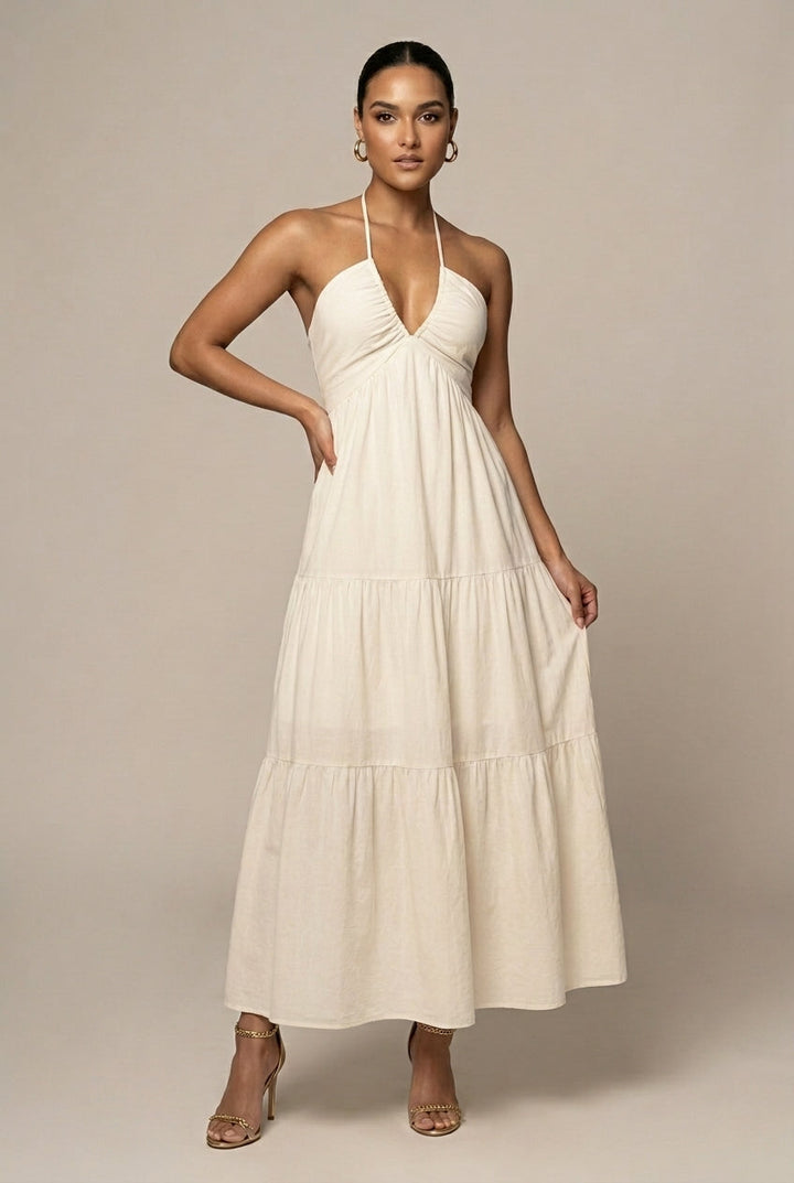Elegant women's halter neck maxi dress with tiered ruffle skirt, open back, and tie waist detail.