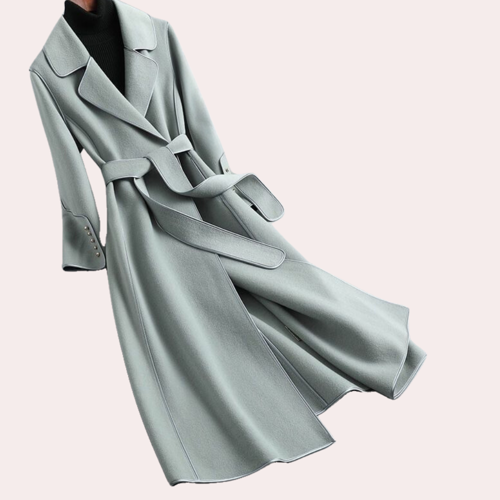Full length view of a woman wearing an elegant long coat, double button design, with a cinched belted waist for style.