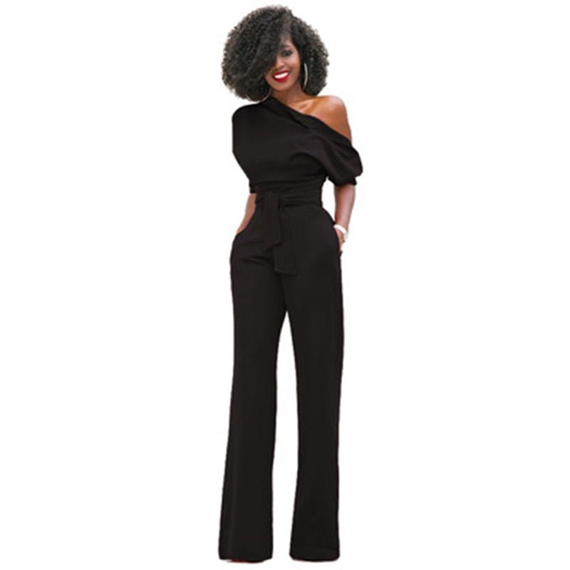 Back view of women's elegant one-shoulder wide-leg jumpsuit, showcasing the flowing silhouette. Modern evening wear.