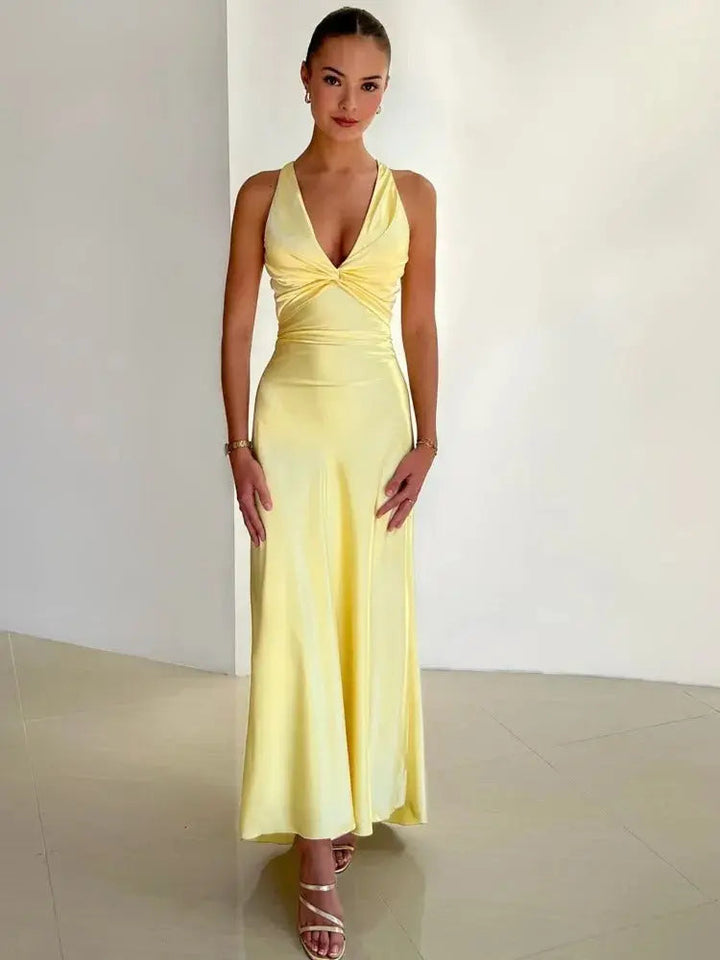 Flowing women's maxi dress, ideal for a wedding guest or formal party, featuring a chic halter neck & open back.