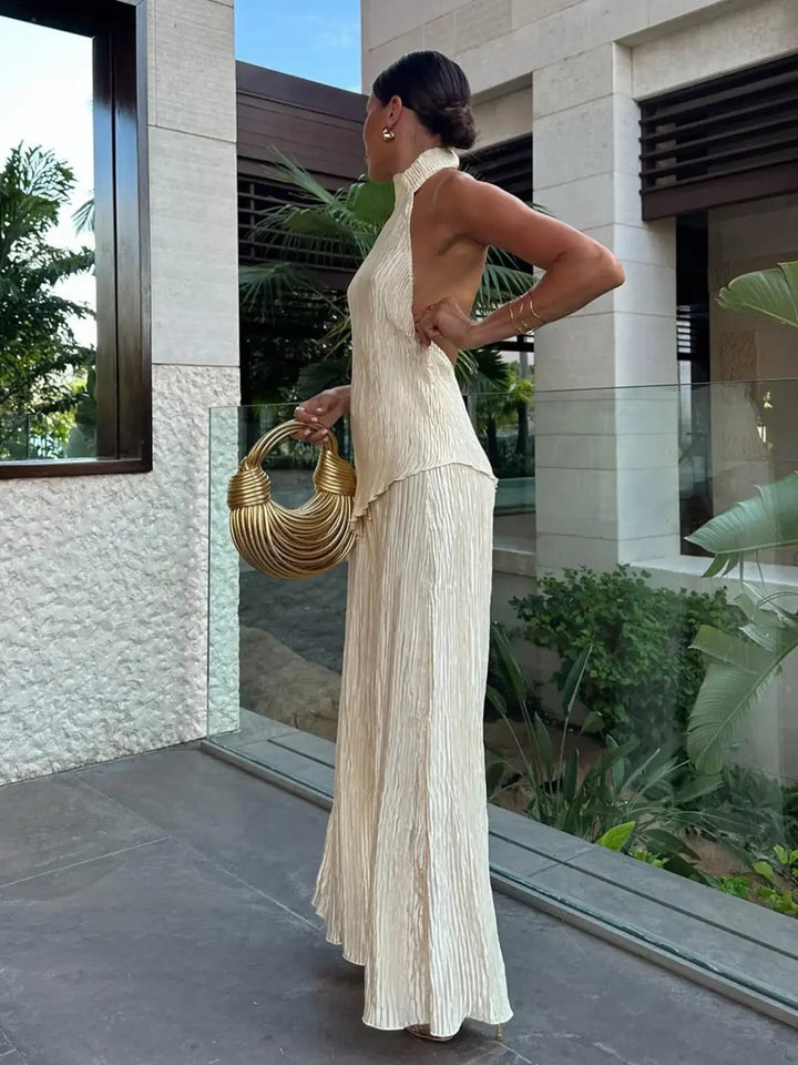 Sophisticated women's two-piece pleated set with a chic halter neck top and flowing wide-leg trousers.