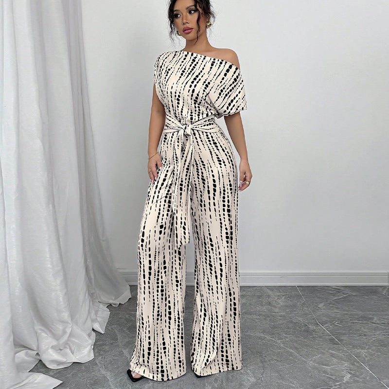 Elegant women's printed one-shoulder wide leg jumpsuit with a chic belted waist, perfect for party or evening wear.