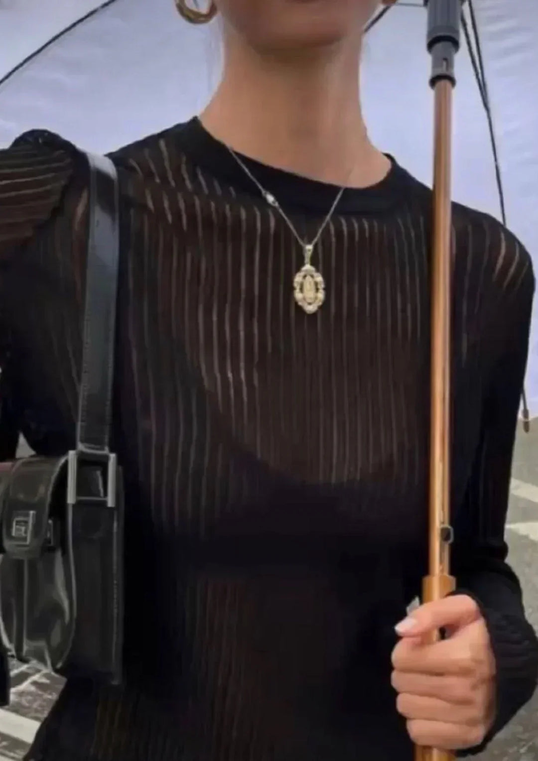 Detailed shot of a sheer ribbed women's long sleeve top, showcasing its unique fabric & elegant drape.