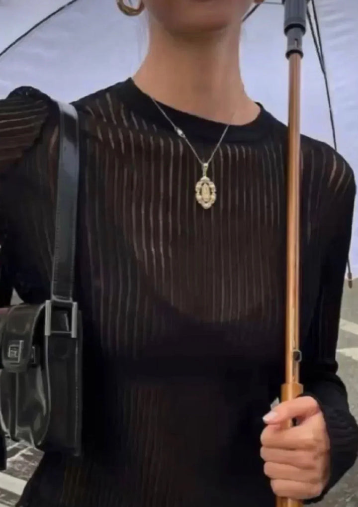Detailed shot of a sheer ribbed women's long sleeve top, showcasing its unique fabric & elegant drape.