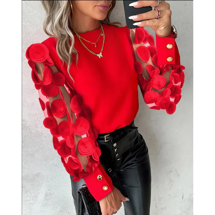 Close-up of the elegant women's sheer sleeve blouse, highlighting the chic appliqué embroidery and round neckline.