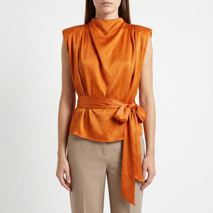 Sleeveless women's blouse with an elegant draped neckline & adjustable tie-waist, offering a chic & flattering fit.