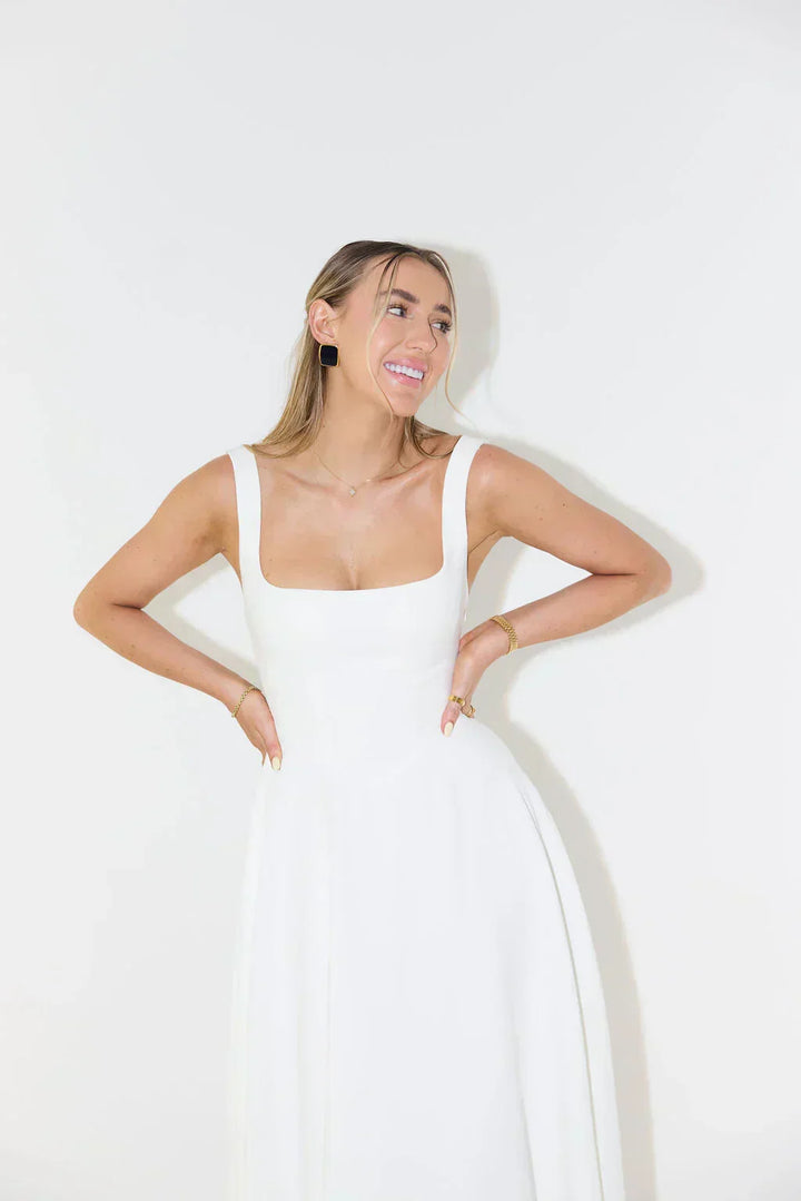 Woman posing in an elegant square neck midi dress. Versatile and comfortable for summer events.