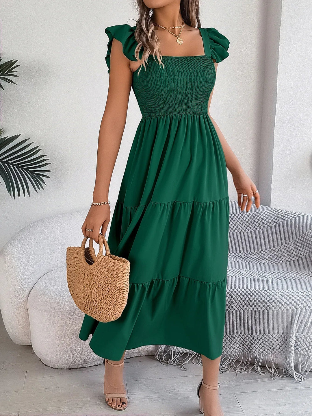 Fashionable women's tiered midi dress with an elegant, flowy design, suitable for various summer events.