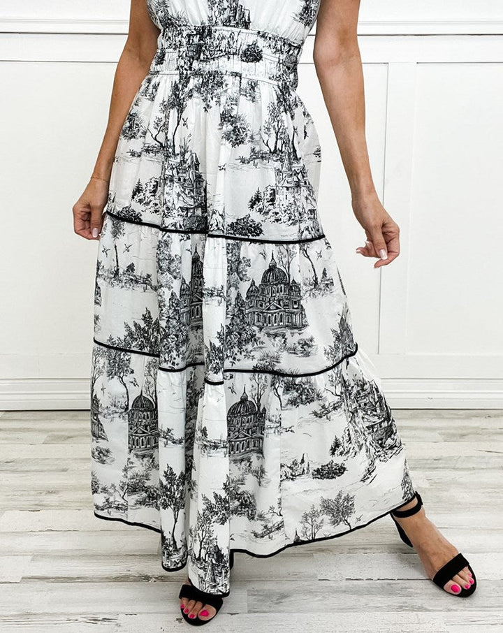 Graceful women's toile print maxi dress. Features smocked waist, V-neck, and tiered skirt for a flowy silhouette.