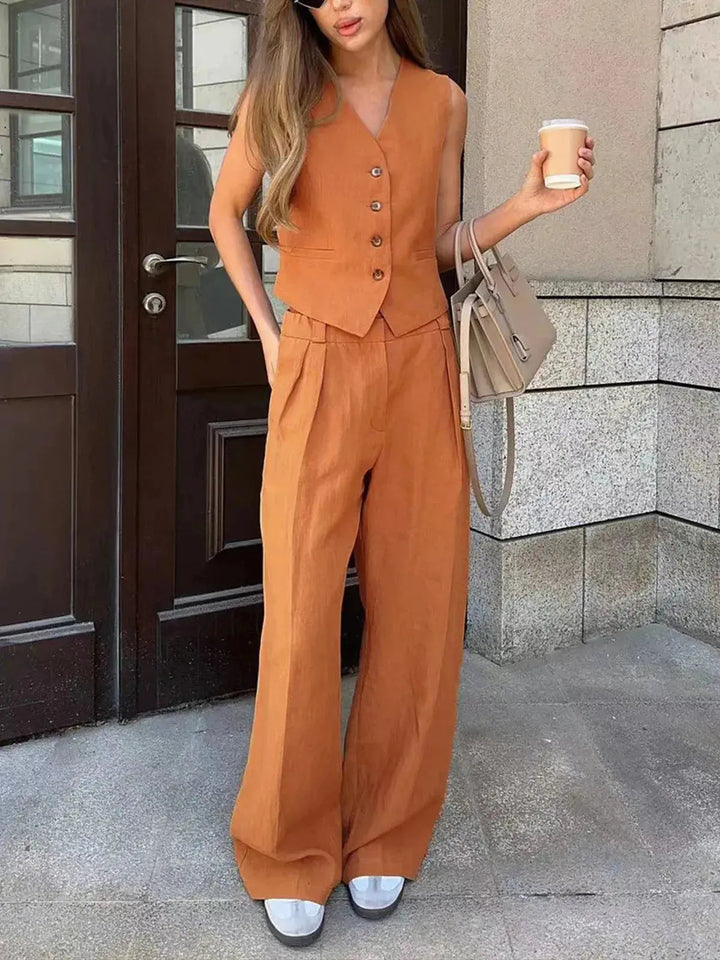 Comfortable women's two-piece outfit featuring a stylish waistcoat and relaxed wide-leg trousers. Smart casual.