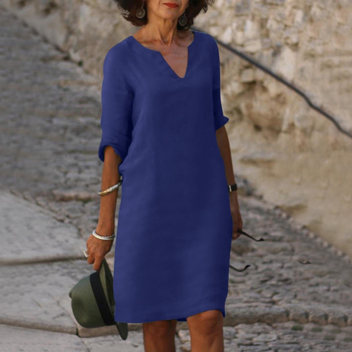 Happy woman in a comfortable V-neck summer midi dress, perfect for casual elegance & sunny spring days.