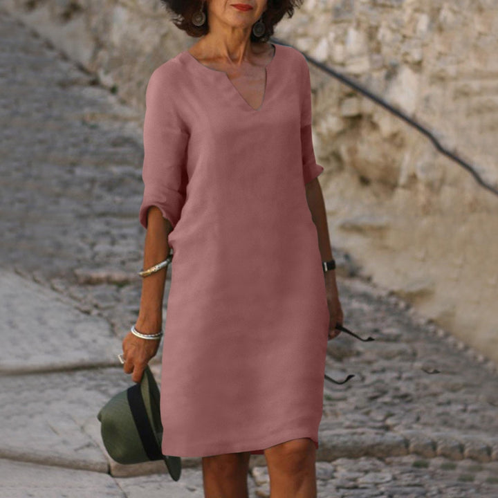 Close-up of soft fabric on a women's V-neck summer midi dress, emphasizing comfort & elegant casual wear.
