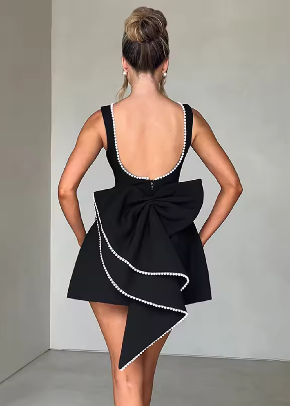 Stylish black open back mini dress for women, featuring a chic bow. Ideal for cocktails & evening events.