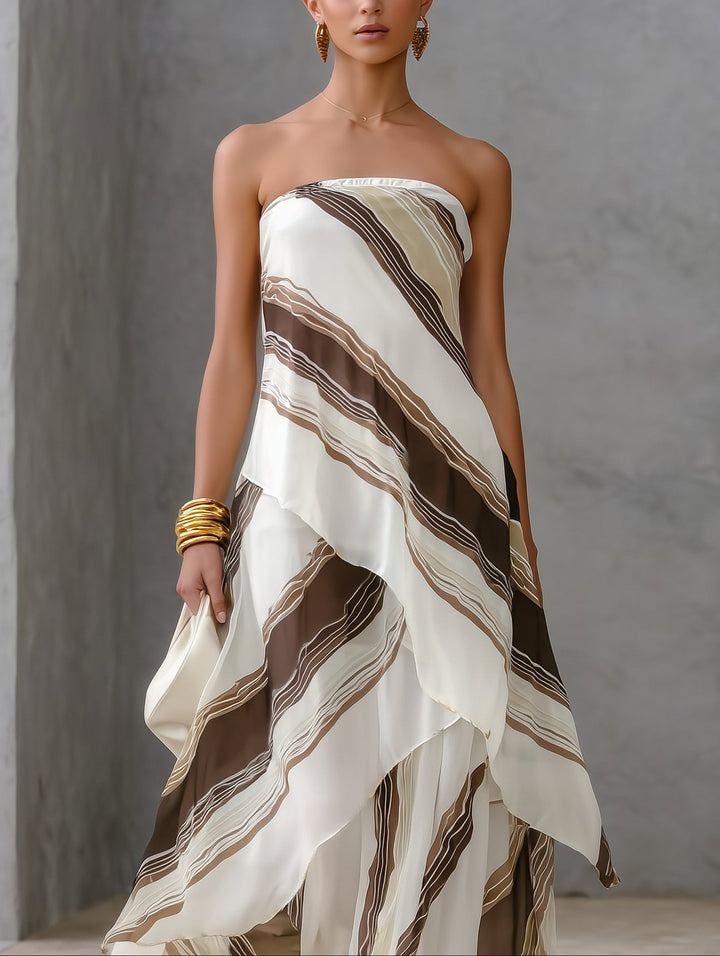 Flowy white & striped strapless maxi dress for women, featuring an elegant asymmetric hem, ideal for special occasions.