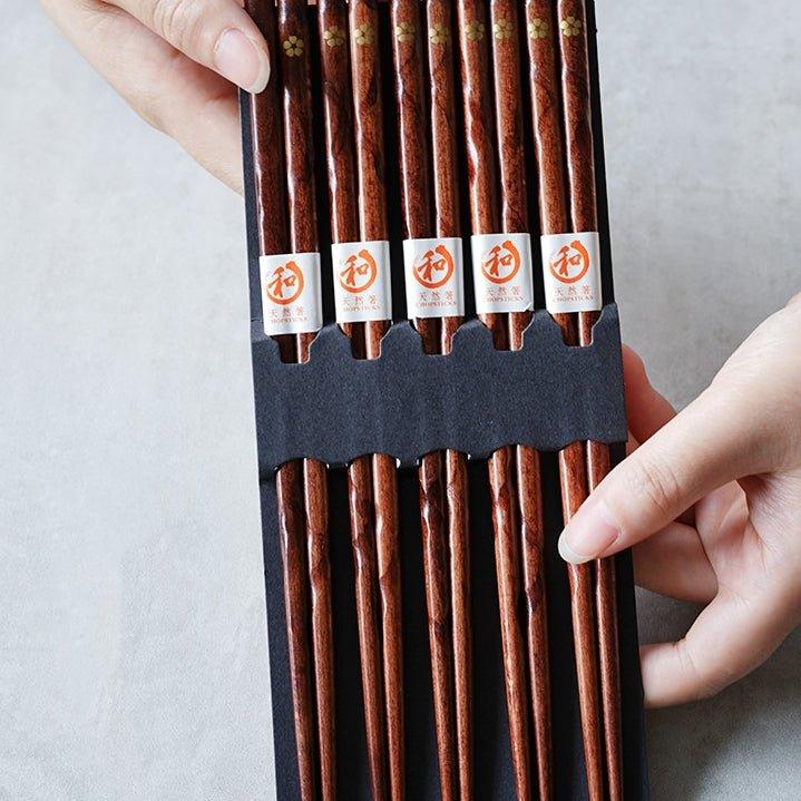 Detailed golden cherry blossom art on elegant wooden chopsticks. Set of 5 pairs, perfect for any special meal.