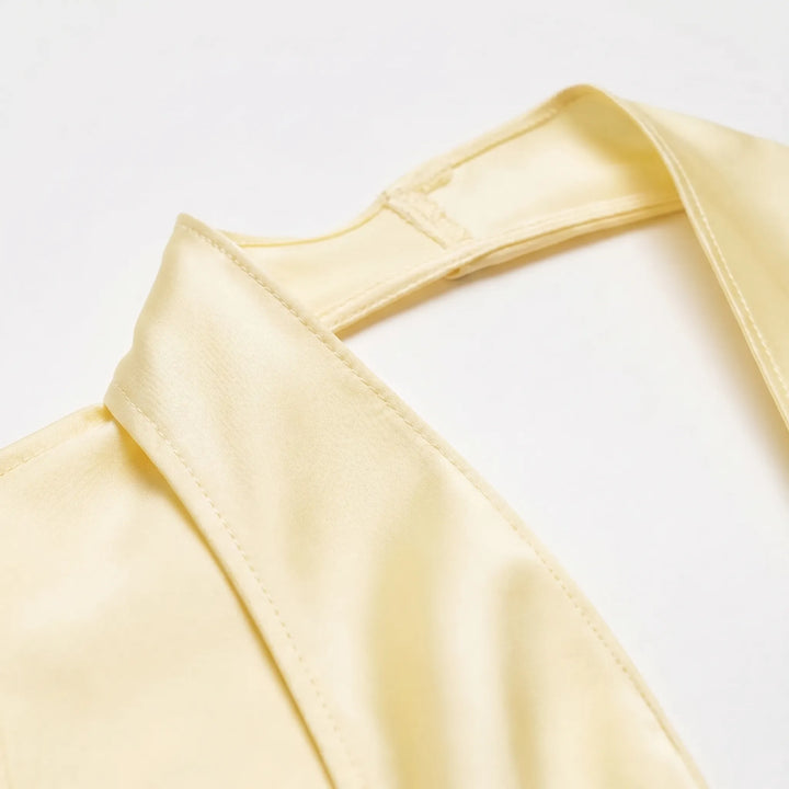Modern ladies' yellow draped halter top, designed with an elegant asymmetrical cut for versatile summer wear.
