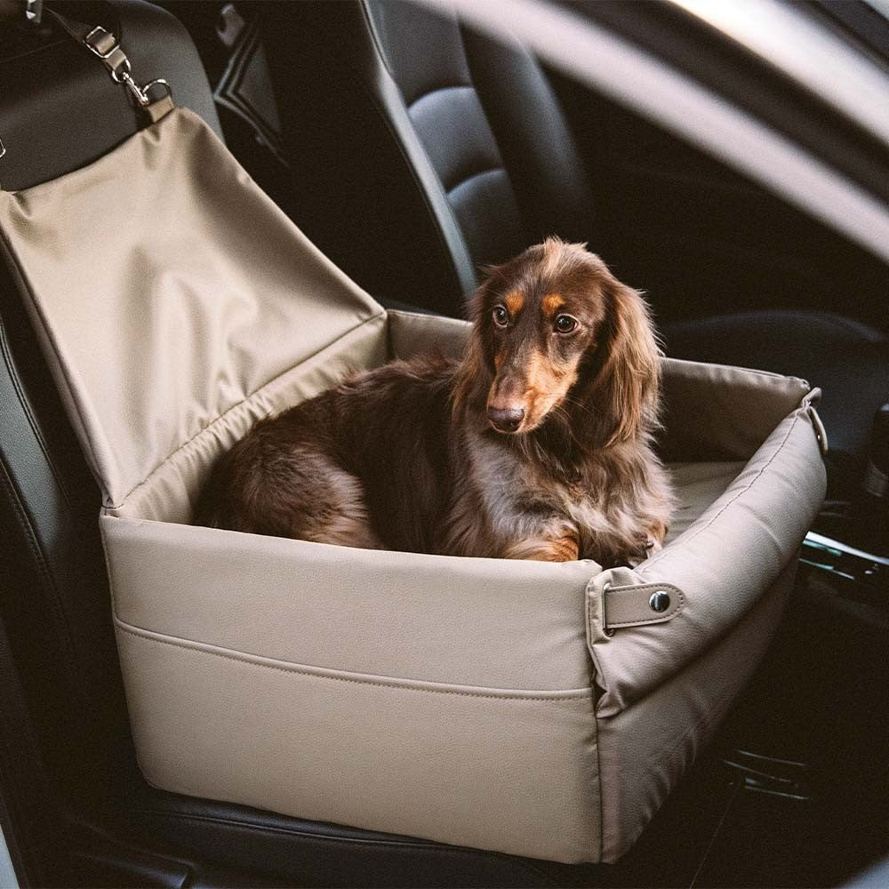 Faux leather elevated pet booster seat in a car, side view, showing secure straps.