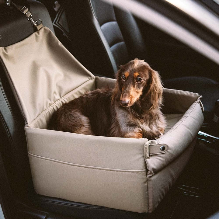 Faux leather elevated pet booster seat in a car, side view, showing secure straps.