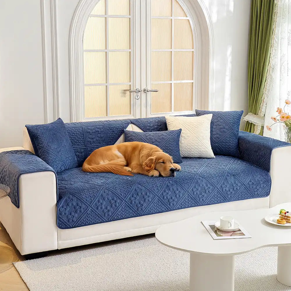 Embossed geometric plush non-slip sofa cover in grey, protecting a three-seater couch, pet friendly.