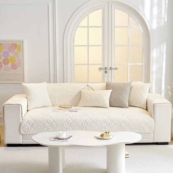 Quilted non-slip sofa cover with an elegant geometric design, enhancing living room furniture protection.