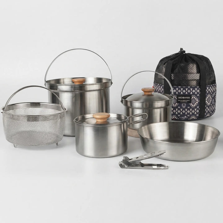 Complete camping pot set with various sized pots and pans, ideal for family outdoor cooking and camp meals.