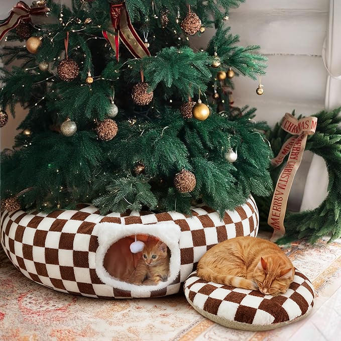 A happy cat peeking out from the top opening of the Christmas Tree Cat Tunnel, surrounded by holiday decor