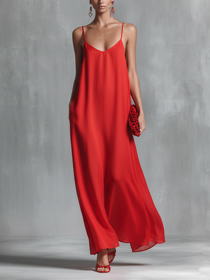Flowy red V-neck maxi dress with spaghetti straps, perfect for elegant evening wear or summer resort fashion.