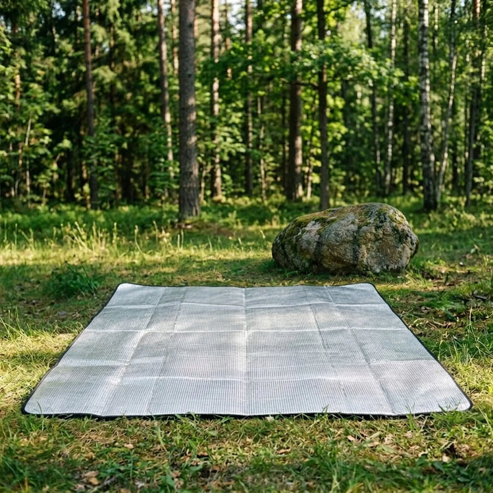 Foldable outdoor camping mat with reflective thermal surface, ideal for hiking and sleeping comfort.