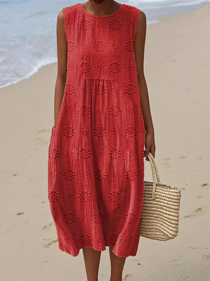 Detail of the breathable fabric of a women's summer midi dress, emphasizing its comfortable, flowy design with practical pockets.
