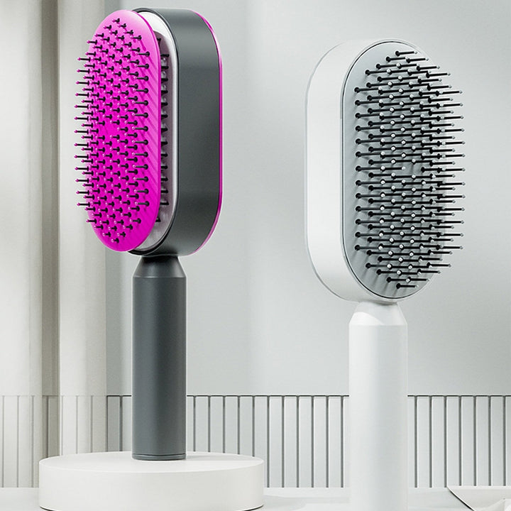 Fuchsia and white self-cleaning detangling brush. Gentle on all hair types, prevents breakage, stimulates scalp.