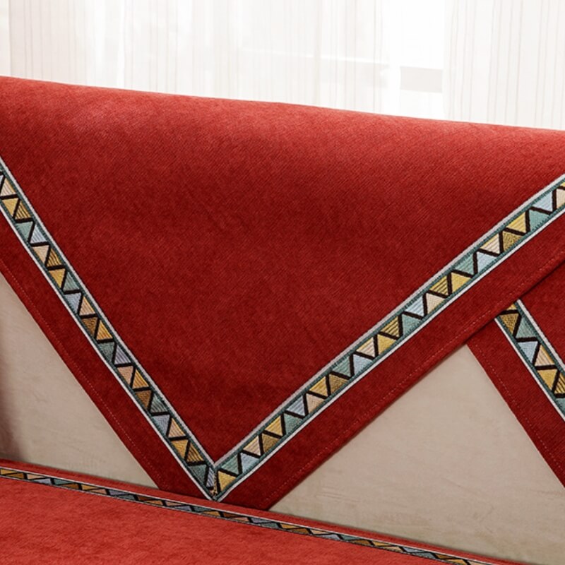 Non-slip geometric chenille sofa cover in blue draped over a couch, furniture protection