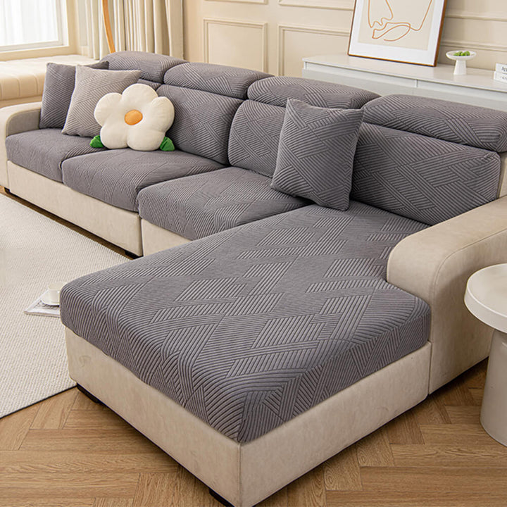 Elegant geometric jacquard stretch furniture protector, enhancing living room while protecting from pets.