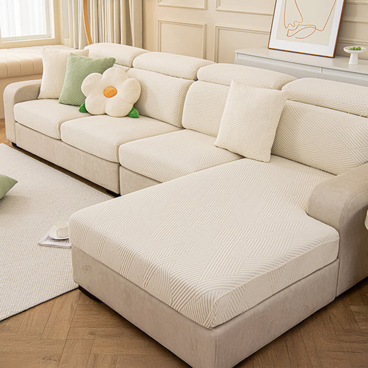 Detail of the durable fabric of a geometric jacquard stretch sofa cover, pet-friendly and resilient.