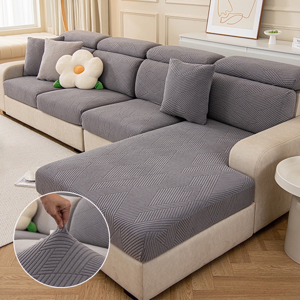 Pet-friendly stretch couch cover with a modern geometric jacquard pattern on a sofa.