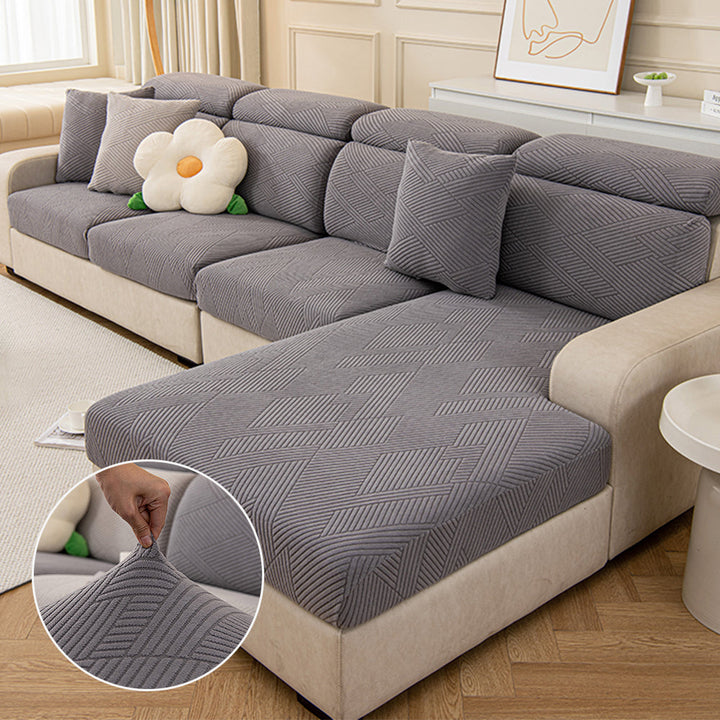 Pet-friendly stretch couch cover with a modern geometric jacquard pattern on a sofa.