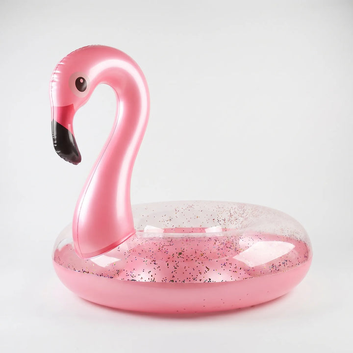 Shimmering pink glitter flamingo pool float, an inflatable water toy for summer fun & beach vacations.