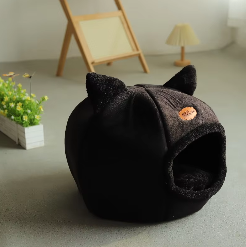 Cozy black cat bed with a cat-shaped design and a plush, removable cushion.