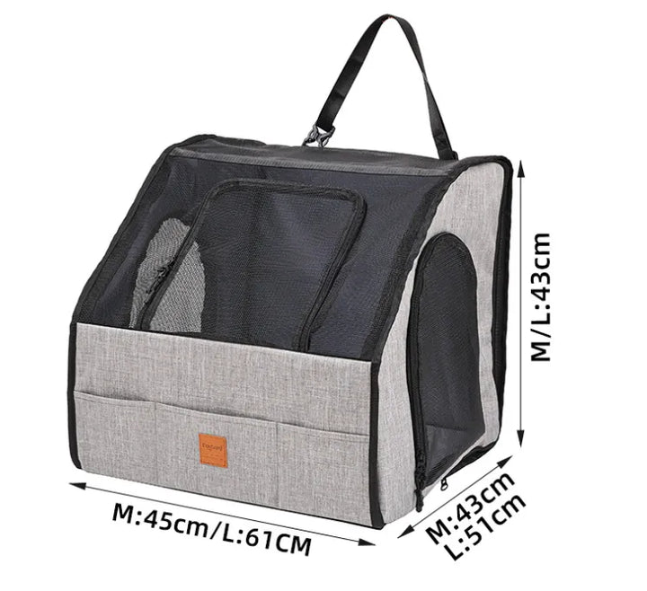 Puppy comfortably seated in gray pet booster with mesh window for visibility.