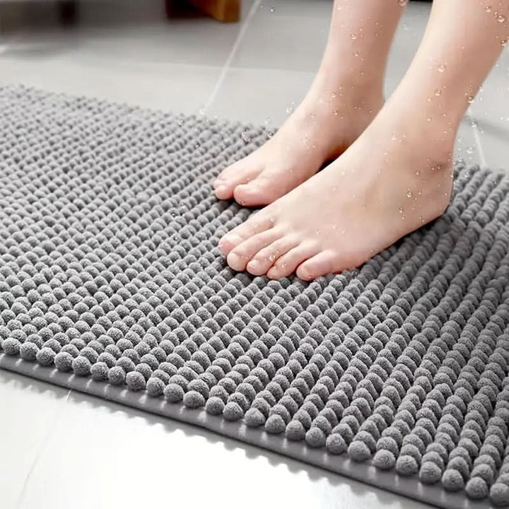 Soft beige chenille floor mat, non-slip & washable. Absorbent bath rug for a comfortable bathroom.