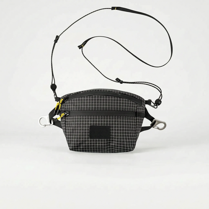 Stylish gray multifunctional crossbody sling bag for men & women, featuring a subtle grid pattern, great for urban travel.